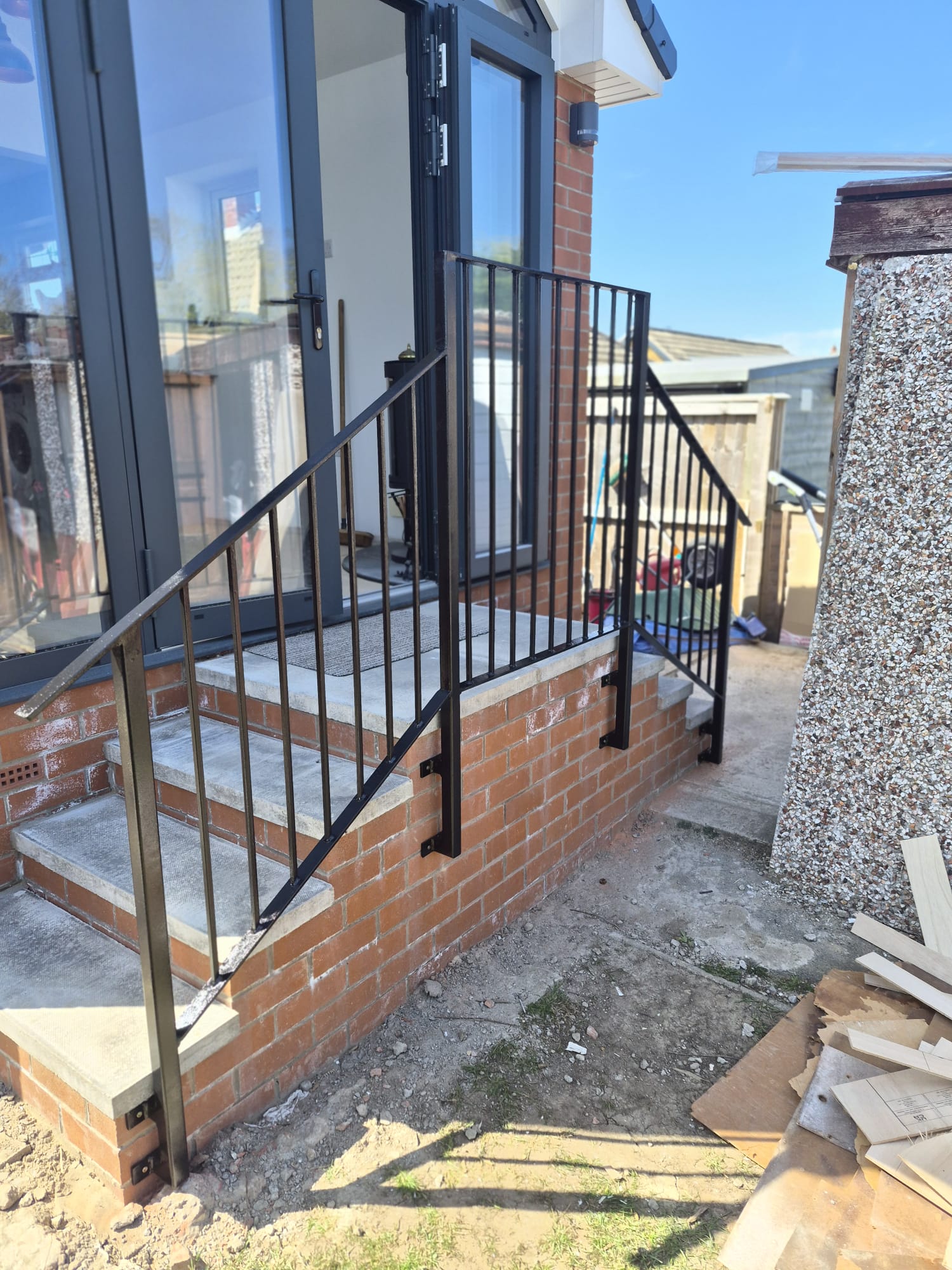 black fabricated railings and handrail installed on brick steps